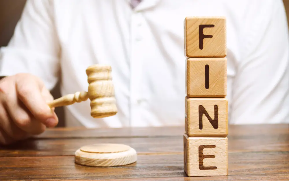 A Man with a Wooden Hammer and Block with Letters Saying Fine — Unfair Dismissal Solutions in Australia