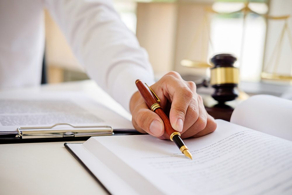 Hand With Pen and Book — Fair Work Advocates in Queensland, Australia